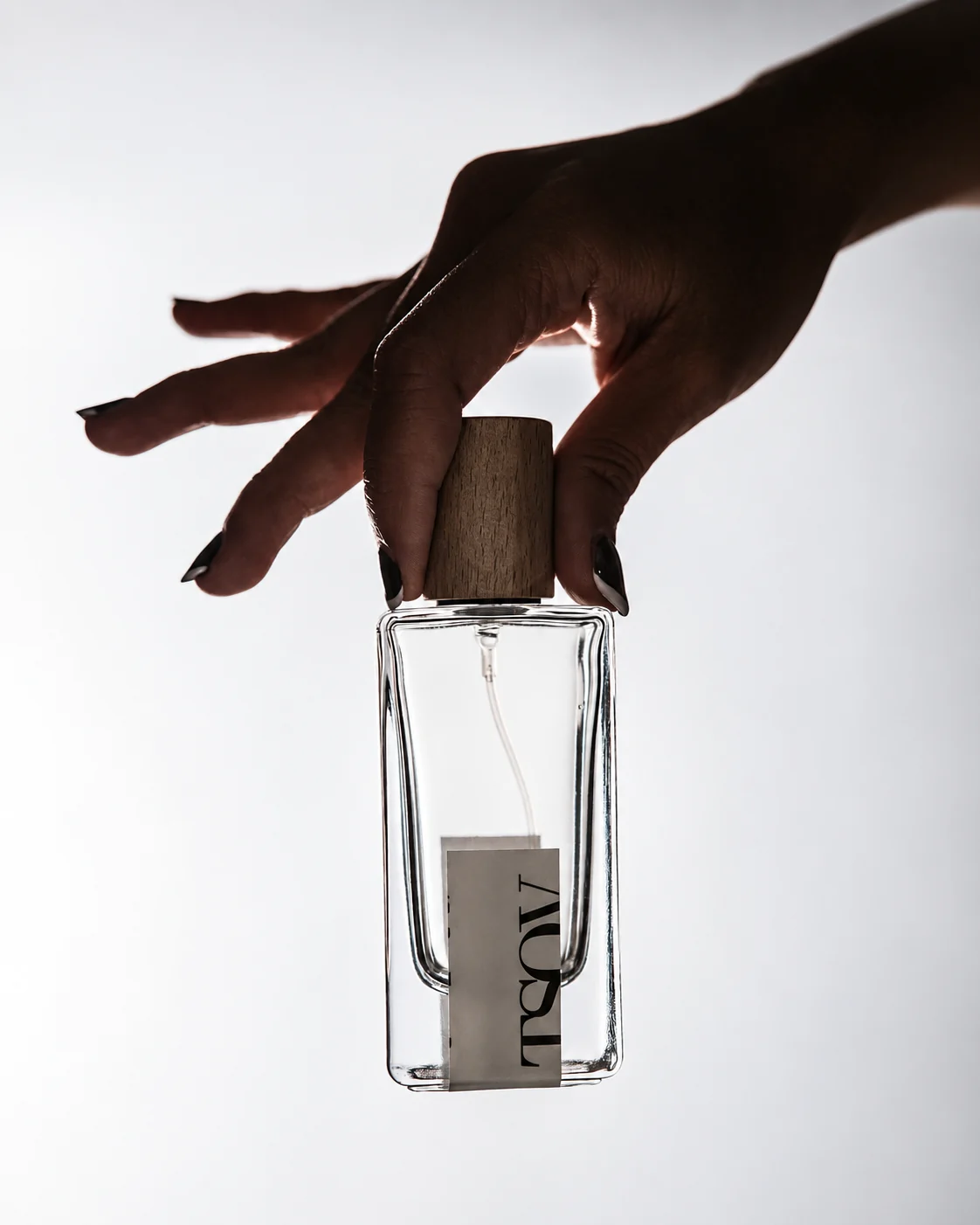 Fragrance editorial, a hand holding a perfume bottle