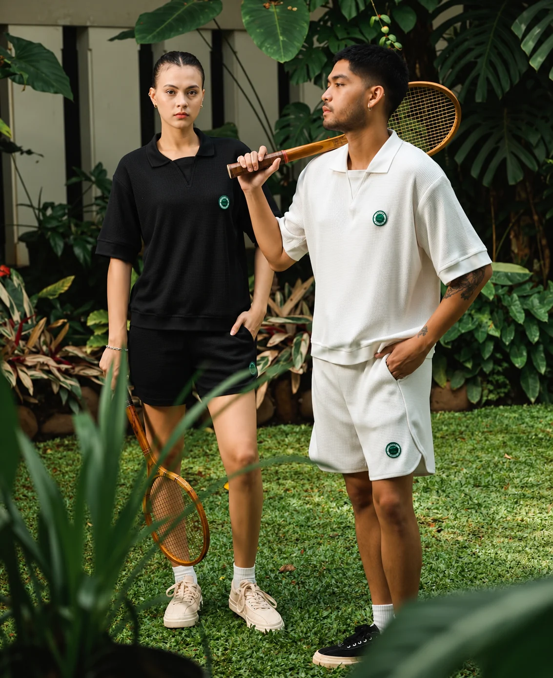 Two models wearing casual sportswear in a garden